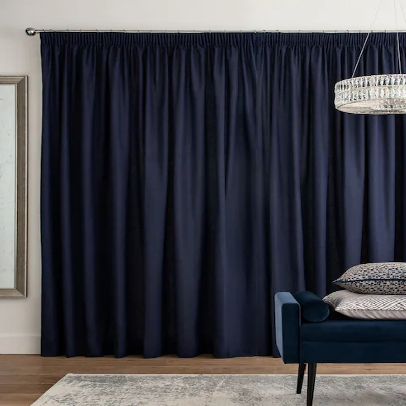 Dark navy pleated curtain in modern interior setting