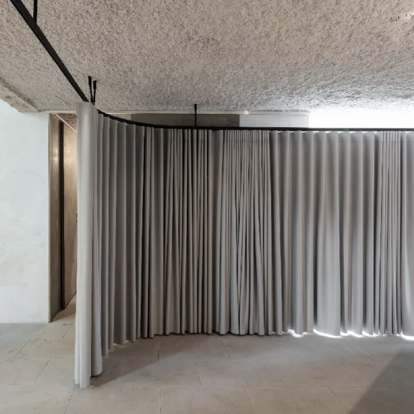 Gray curved track soundproof curtain in office setting.
