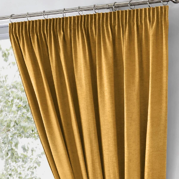 mustard yellow pinch pleat blackout curtain on a track