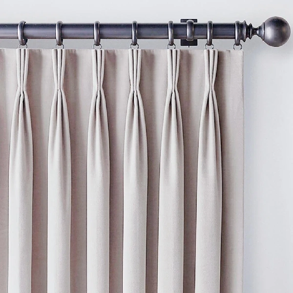 taupe tailored pinch pleat blackout curtain on a dark metal rod
