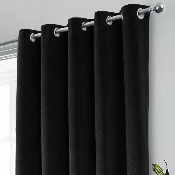 suede blackout curtains with silver grommets on a rod.